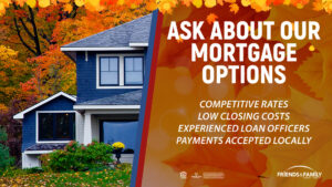 A blue house surrounded by fall foliage