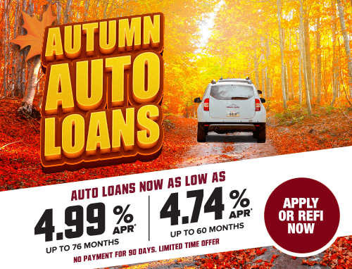 A white car surrounded by fall foliage